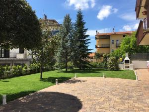 un jardín con una pasarela de ladrillo y un edificio en Villa Andalù Appartamenti en San Giovanni Rotondo