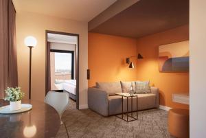 a living room with a couch and a table at Adina Apartment Hotel Dusseldorf in Düsseldorf