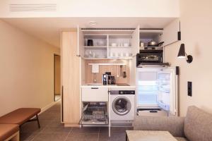 - une cuisine avec lave-linge et sèche-linge dans la chambre dans l'établissement Adina Apartment Hotel Dusseldorf, à Düsseldorf