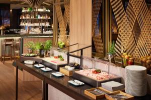 a buffet line with food on display in a restaurant at Adina Apartment Hotel Dusseldorf in Düsseldorf