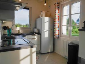 kuchnia z białą lodówką i oknem w obiekcie Maison Neuve Confortable Proche Plages à Locmaria – Jardin, Terrasse, Wifi, Classée 3* - FR-1-418-209 w mieście Locmaria +15 zdjęć