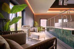 a waiting room with couches and chairs and plants at Adina Apartment Hotel Dusseldorf in Düsseldorf