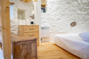 a bedroom with a bed and a stone wall at Traditional Windmill - 50m from the Sea in Lampi