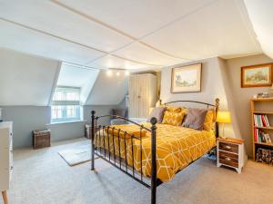a bedroom with a bed with a yellow blanket at The Innkeep in Watlington