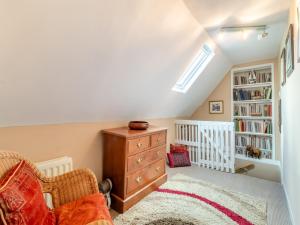 a attic room with a dresser and a book shelf at The Innkeep in Watlington