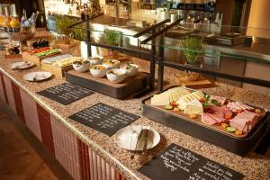 a buffet with meats and cheese on a table at Adina Apartment Hotel Stuttgart in Stuttgart