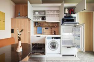a kitchen with a washer and dryer and a table at Adina Apartment Hotel Stuttgart in Stuttgart