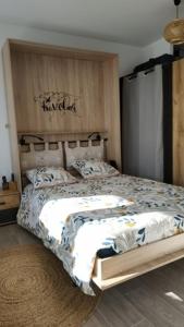 een slaapkamer met een groot bed met een houten hoofdeinde bij Superbe studio, vue lac, Spirou, rando, velo in Monteux