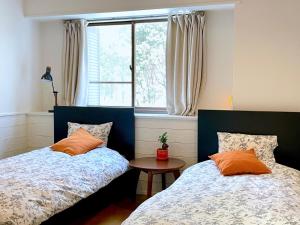 1 dormitorio con 2 camas y ventana en Foresta Karuizawa 1, en Oiwake