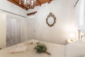 ein weißes Schlafzimmer mit einem großen Bett mit Handtüchern darauf in der Unterkunft Ktima Dimitrios in Naxos Chora
