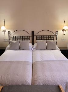 two beds sitting next to each other in a bedroom at Hotel Rural Candela y Plata in Puerto de Béjar