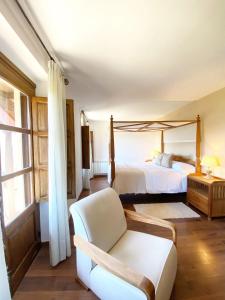 um quarto com uma cama, um sofá e uma cadeira em Hotel Rural Candela y Plata em Puerto de Béjar