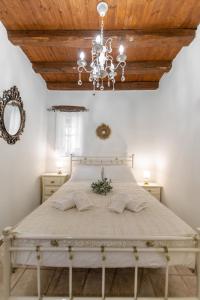 ein Schlafzimmer mit einem großen Bett mit einem Kronleuchter in der Unterkunft Ktima Dimitrios in Naxos Chora