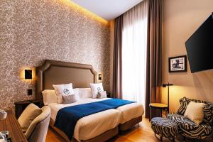 a hotel room with a bed and a chair at Boutique Hotel Cordial Plaza Mayor de Santa Ana in Las Palmas de Gran Canaria