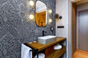 a bathroom with a sink and a mirror at Boutique Hotel Cordial Plaza Mayor de Santa Ana in Las Palmas de Gran Canaria