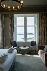 a bedroom with a bed and a large window at Corran House Guest House in Oban