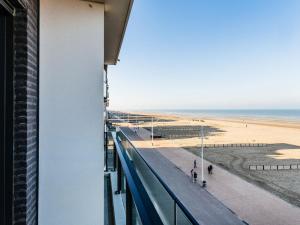 a view of the beach from the balcony of a building at Modern luxury new build apartment on the Zeedijk in Koksijde