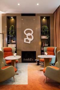 a waiting room with two tables and a fireplace at Hotel Montalembert in Paris