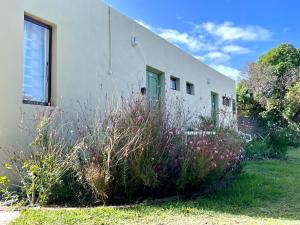 a building with some plants in front of it at Kelp Cottage - Two Private Garden en-suite Rooms in Gansbaai
