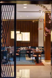 a dining room with tables and chairs and a staircase at Hotel Montalembert in Paris