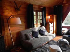 una sala de estar con sofá en una cabaña de madera en Le Petit Skieur B&B, en Le Sappey-en-Chartreuse