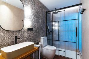 a bathroom with a sink and a toilet and a mirror at Boutique Hotel Cordial Plaza Mayor de Santa Ana in Las Palmas de Gran Canaria