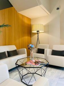 a living room with white furniture and a glass table at Hotel Oria in Tolosa