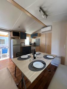 a kitchen with a table with two plates on it at Mobil home 8 personnes camping L'Elysée Vagues Océanes in Le Grau-du-Roi