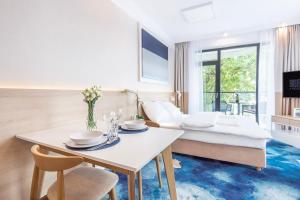 un salon avec une table et un lit dans l'établissement VacationClub - Boulevard Residence Apartament 24, à Ustronie Morskie