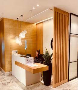 a woman sitting at a counter in a lobby at Hotel Oria in Tolosa