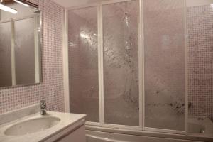 La salle de bains est pourvue d'une douche en verre et d'un lavabo. dans l'établissement Alex's lake house, à Riva di Solto