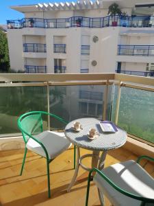 een balkon met een tafel en stoelen en een gebouw bij Port Plage Centre Ville et Soleil in Saint-Raphaël