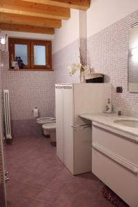 ein Badezimmer mit 2 WCs, einem Waschbecken und einem Spiegel in der Unterkunft Alex's lake house in Riva di Solto
