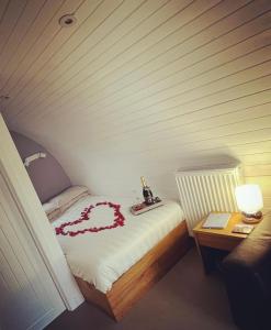 una camera con un letto con un cuore rosso sopra di Loch Ness Pods, Pod 2 a Fort Augustus
