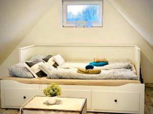 uma cama com um ursinho de peluche num quarto em FeWo SEEBLICK - Familien - Hunde - strandnah - Ostseeblick - Sauna & Wellness em Sierksdorf