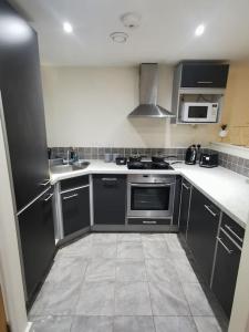 eine Küche mit schwarzen und weißen Schränken und Geräten in der Unterkunft Paramount city view in Swindon