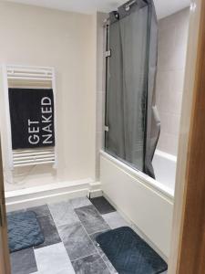 a bathroom with a shower and a tiled floor at Paramount city view in Swindon