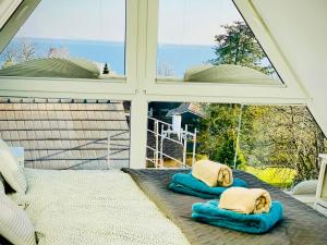 a window with two pillows on a bed on a porch at FeWo SEEBLICK - Familien - Hunde - strandnah - Ostseeblick - Sauna & Wellness in Sierksdorf