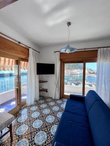 sala de estar con sofá azul y balcón en Suite Capri, en Isquia