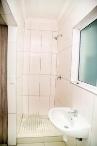 a white bathroom with a sink and a window at AS Guesthouse & Self-catering in Swakopmund