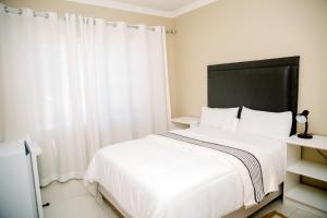 a bedroom with a white bed and a window at AS Guesthouse & Self-catering in Swakopmund