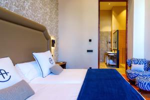 a hotel room with a bed and a chair at Boutique Hotel Cordial Plaza Mayor de Santa Ana in Las Palmas de Gran Canaria