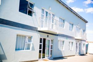 a white building with a balcony on the side of it at AS Guesthouse & Self-catering in Swakopmund