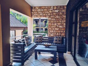 eine Veranda mit einer Bank und einem Tisch auf dem Balkon in der Unterkunft Ecotel Premier Lodge & Conference Centre in Benoni