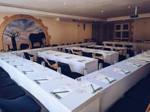 Großes Zimmer mit weißen Tischen und Stühlen in der Unterkunft Ecotel Premier Lodge & Conference Centre in Benoni