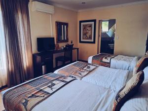 a hotel room with two beds and a television at Ecotel Premier Lodge & Conference Centre in Benoni