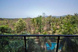 una vista dal balcone di un resort alberato di Palolem Comfy and Cozy Apartment a Canacona