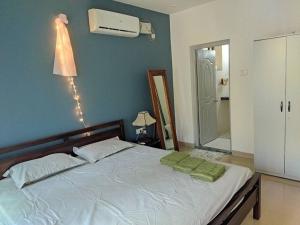 a bedroom with a bed with green pillows on it at Palolem Luxury Apartments in Canacona