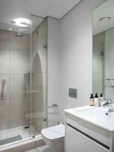 a bathroom with a shower and a sink and a toilet at eKhaya at Ellipse Waterfall City in Midrand