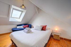 sypialnia z dużym białym łóżkiem i oknem w obiekcie Imagine - Charmante maison avec jardin w mieście Vannes